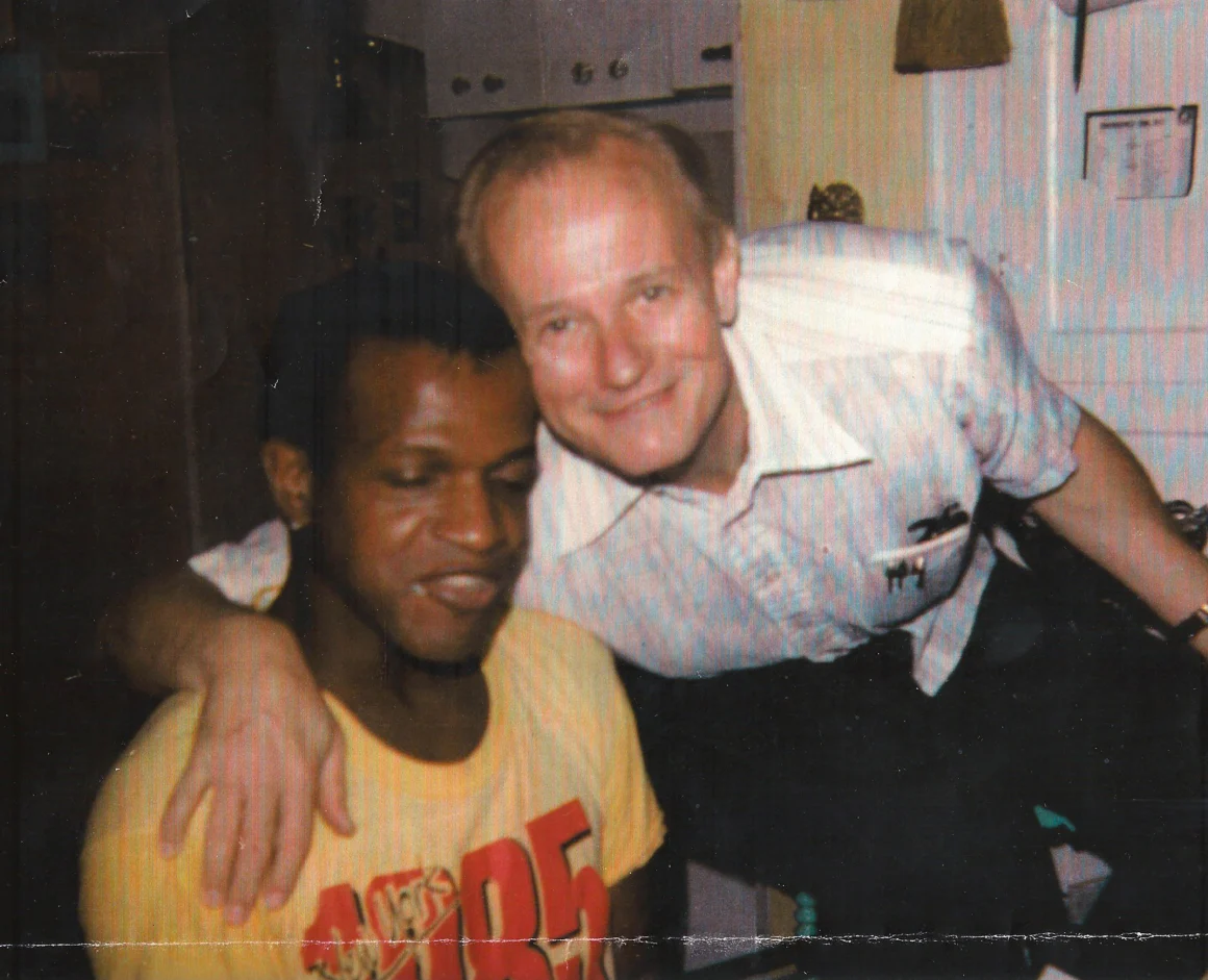 wicker smiles with an arm around johnson whose eyes are closed